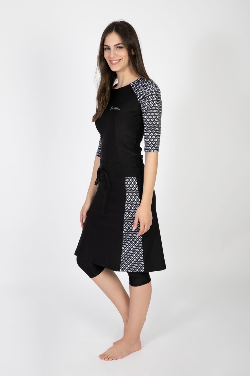 Model wearing the Long Three-Piece Swim Set with raglan-sleeve top, knee-length skirt and capri leggings